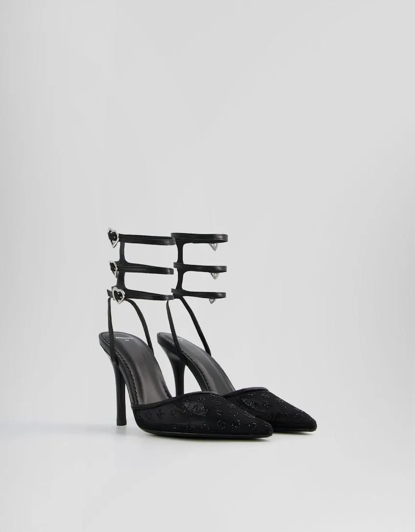 Shiny high-heel shoes with ankle straps and heart-shaped buckles.