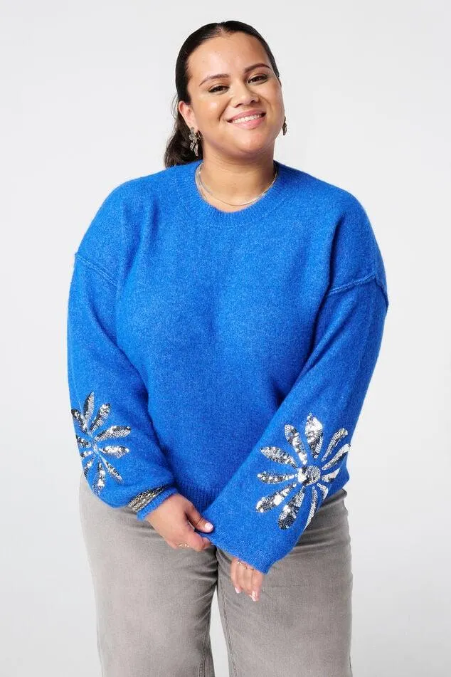 Gebreide trui met pailletten op de mouwen