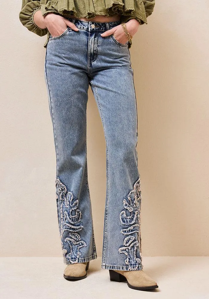 Jeans con aplicacion deflecada en botas