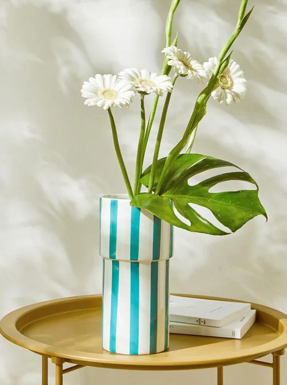 Jarrón de rayas azules sobre fondo blanco