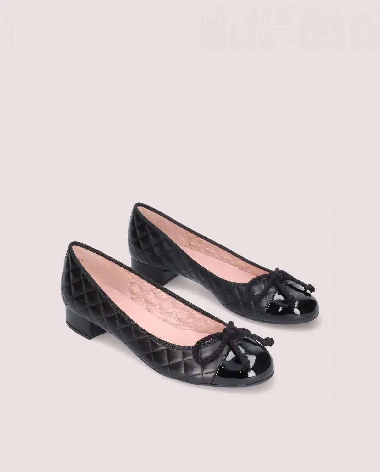 Bailarina modelo Gretschen en napa acolchada negra con puntera de charol, lazo negro y tacón de 2.5cm, suela de goma, plantilla de piel y forro de tela