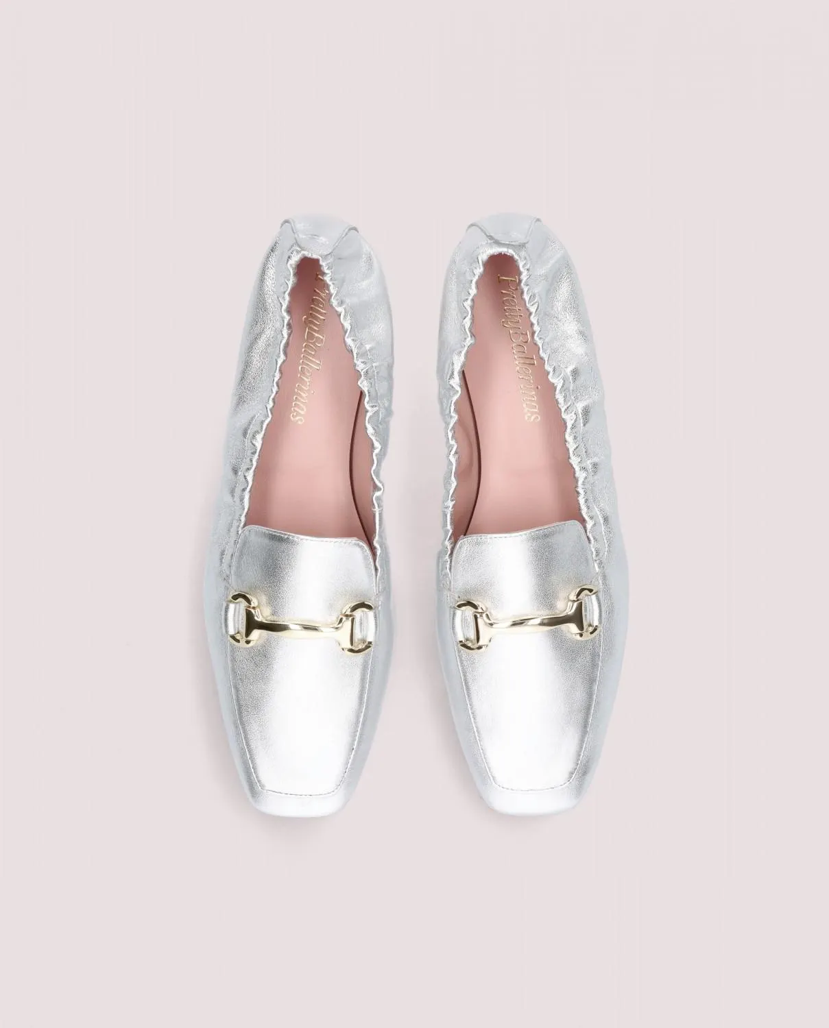 Loafer de punta cuadrada modelo Camille en napa plateada con hebilla dorada y falla elástica, suela de goma, plantilla y forro de piel.