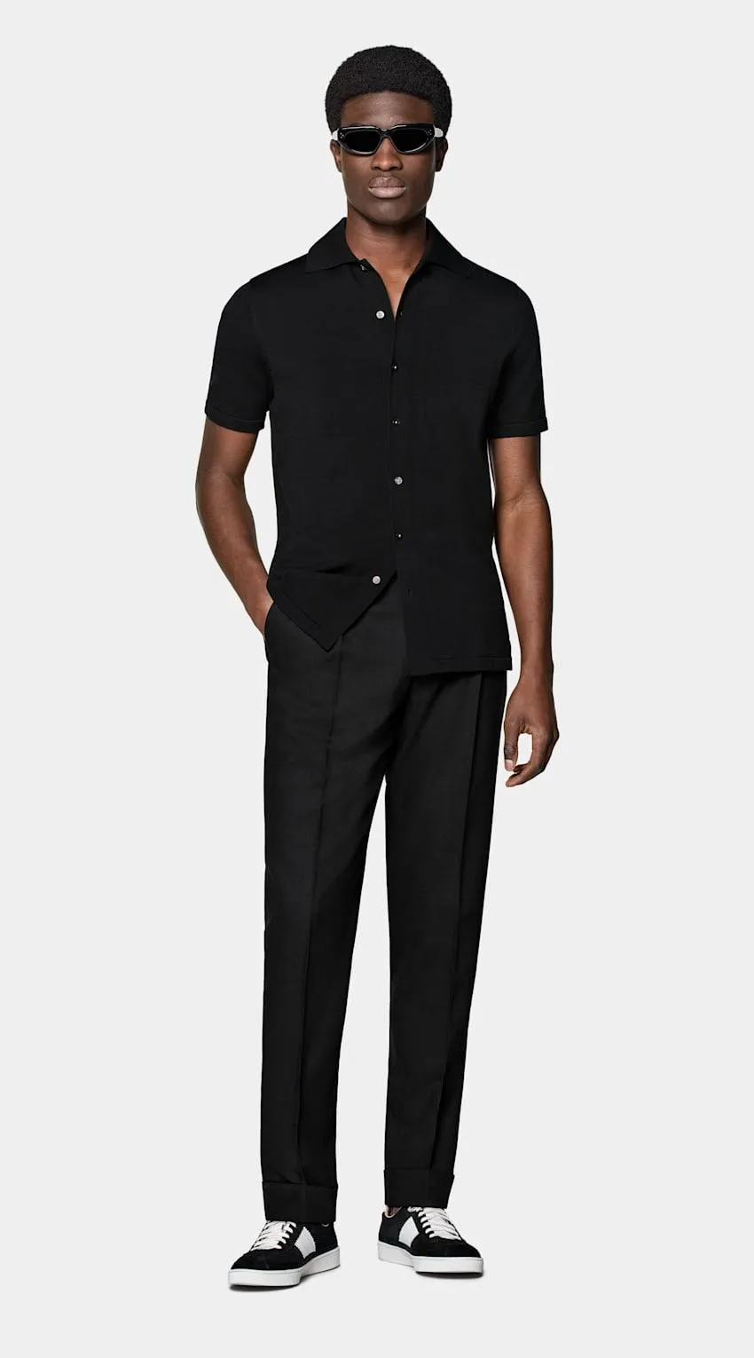 A perfect way to elevate any casual look, this black short-sleeve polo cardigan features a classic polo collar, a seven-button closure, and a slim, tapered silhouette for a sleek aesthetic.