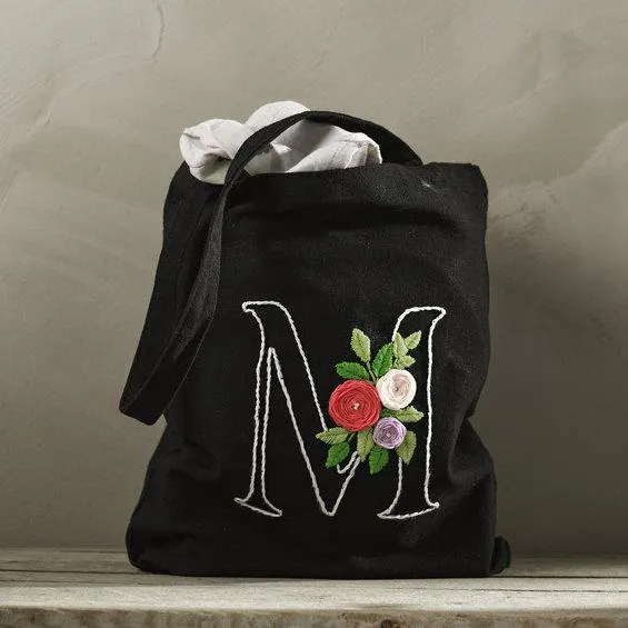 Broder et handlenett i tekstil, og gi det et personlig preg med bokstav og blomster