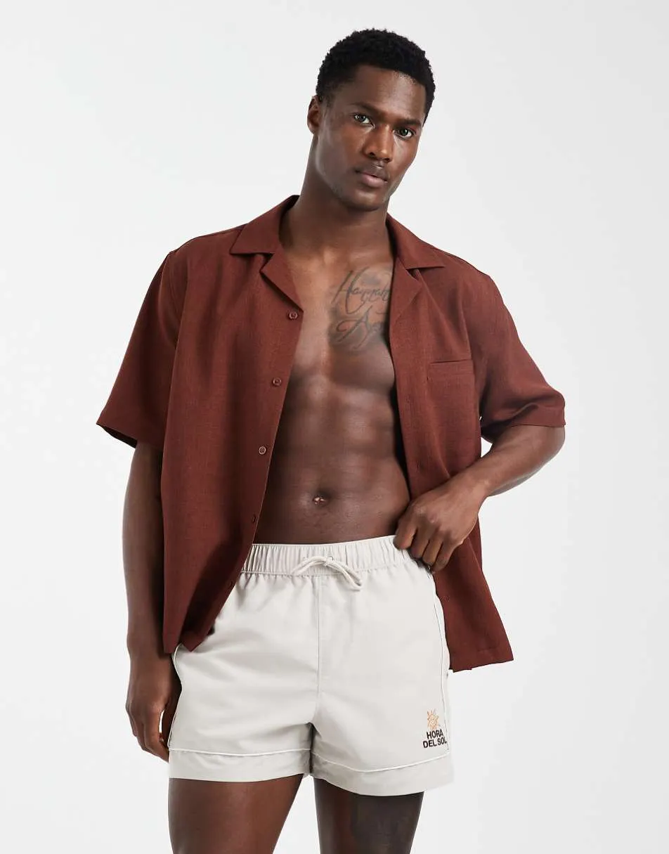 ASOS DESIGN swim shorts in short length with embroidery in beige