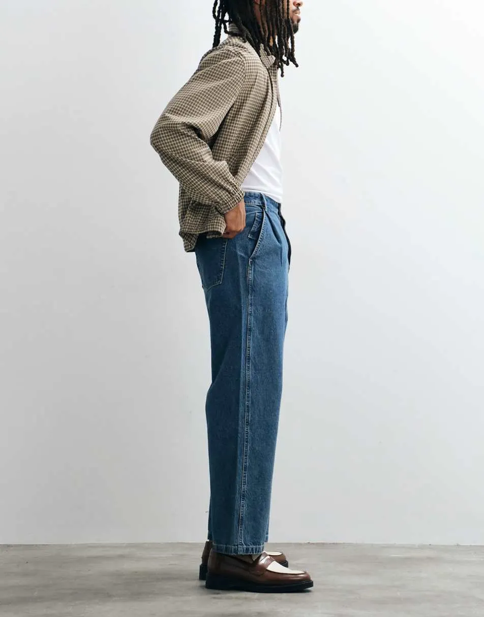ASOS DESIGN relaxed tapered jeans in mid wash blue with pleats and buckle
