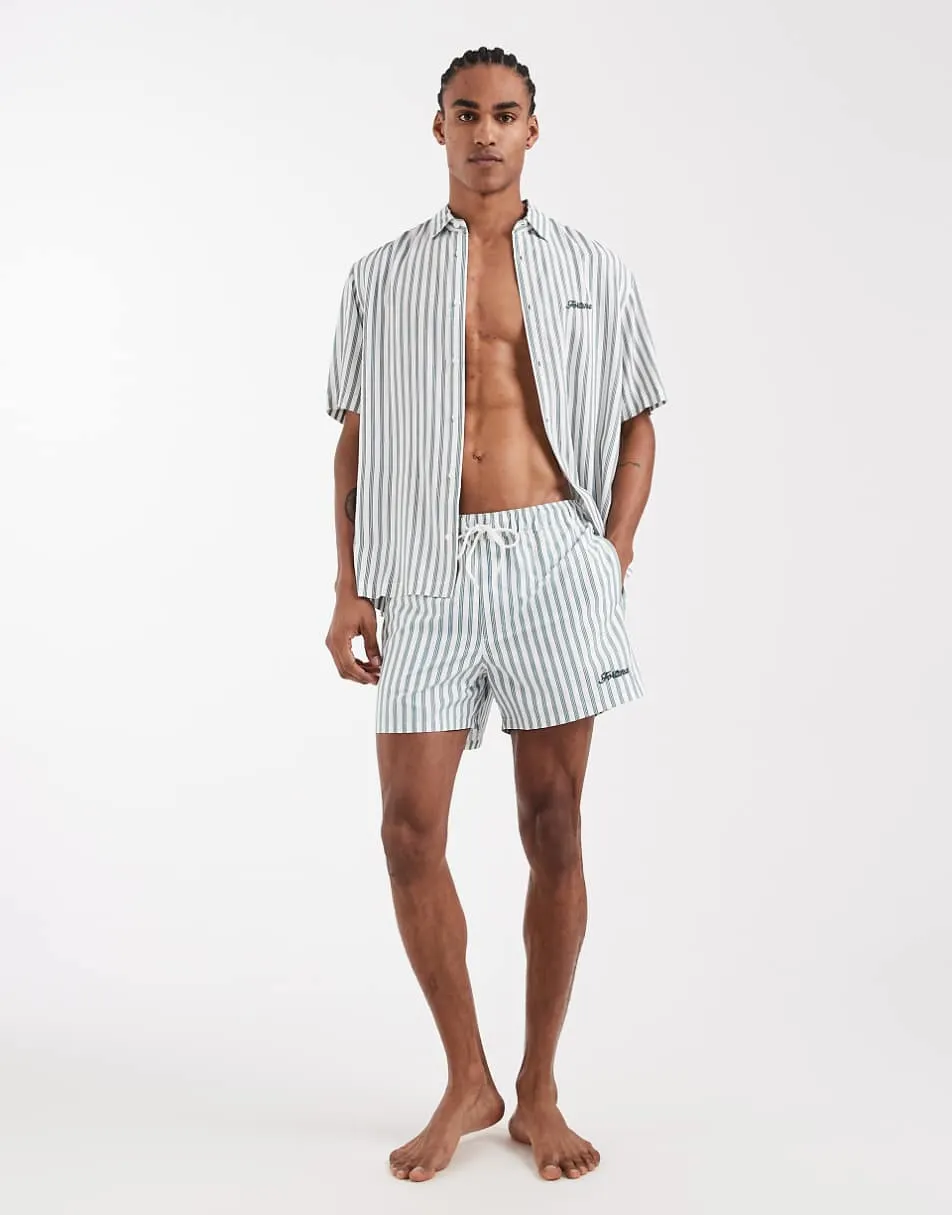 ASOS DESIGN swim shorts in short length with green stripe and embroidery in white