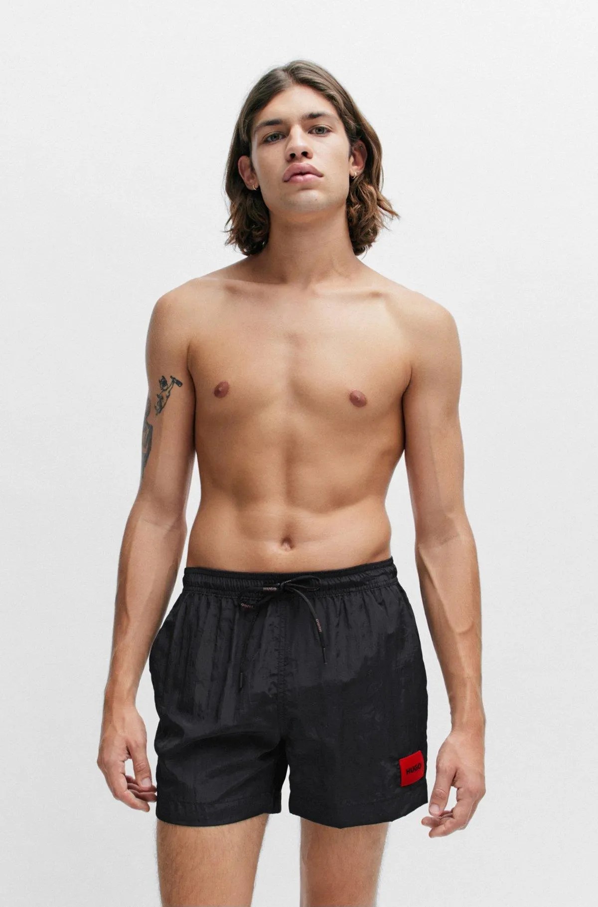 Bañador tipo shorts con forro integral y etiqueta con logo roja